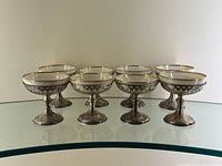 Eight dessert goblets arranged in two rows on glass surface