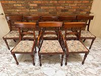 Front view of eight walnut dining chairs arranged in two rows