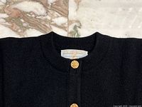 Close-up of neckline showing label and top gold-tone button