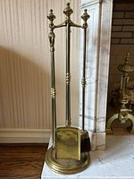 Full front view of brass-tone tool set on round base