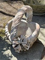 Front angle showing the twisted handle, large flower accents near base of handle and woven basket texture.