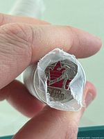 Close-up of the end of one coin roll showing the 2006 Cindy Klassen quarter with red maple leaf detail.