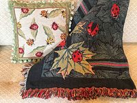 Both the decorative ladybug pillow and the throw blanket displayed together on a couch, showing the ladybug theme matching in colors and design.