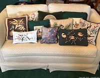 Overview of nine assorted decorative throw pillows on a sofa