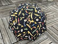 Top view showing black umbrella canopy with multi-colored high heel shoes and butterfly pattern