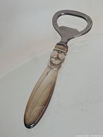 Full length view showing silver handle and stainless steel opener head