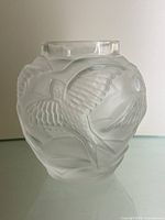 Front side of a frosted lead crystal vase showing detailed embossed bird pattern with frosted texture and clear top rim.
