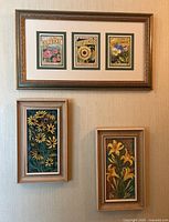 Photo showing all three framed floral artworks hung on a wall: one horizontal print with three flower illustrations above two vertical hand-painted floral tiles.