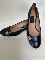 Front view of both pumps showing metal Gancini hardware detail