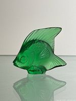 Front view of green glass Lalique fish figurine showing detailed fins and scales.
