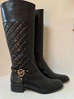 Left-side front angle view of the pair showing quilted shaft and smooth leather foot.