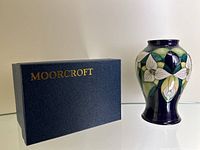 Original Moorcroft presentation box with gold logo alongside vase