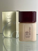 Bottle and original gold-colored box front view showing branding and product details.