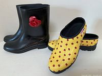 Black rubber boots and yellow ladybug clogs
