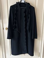 Full front view of black cashmere coat on hanger