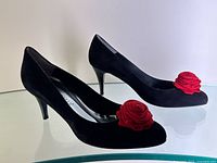 Three-quarter side view of both heels showing overall shape, suede texture, and rose embellishment