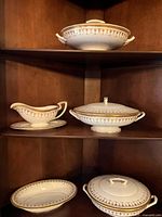 Full display of all five serving pieces on wooden shelf showing three covered dishes, gravy boat with underplate and open vegetable dish