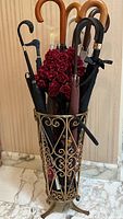 Metal stand filled with assorted umbrellas