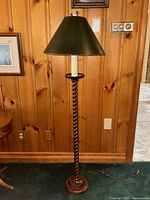 Full front view showing barley twist walnut base, circular foot, green shade, and power cord.