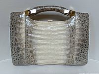 Front view of handbag showing crocodile pattern and hardware