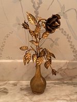 Full view of the vintage gilded metal rose sculpture from front showing vase base and rose with leaves and buds