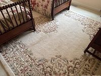 Full room view under twin beds showing the rug’s overall pattern and scale