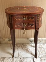 Full front view of kidney-shaped top table with two drawers, legs and marquetry pattern visible