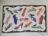 Full view of rug showing all shoe motifs and olive green border