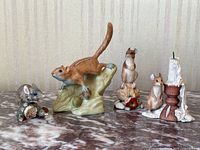 All five figurines displayed together on marble surface: one chipmunk and four mice figurines, including one with a candlestick.