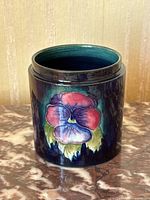Front view of Moorcroft jar with floral pansy design showcasing vibrant colors and glossy finish.