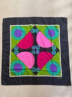 Full view of the vintage Fiorio silk scarf showing the pop art geometric pattern with vibrant colors on a black background.