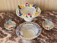 Group view of all four porcelain pieces on marble surface