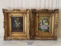 Both floral oil paintings in gilt frames side by side against wall