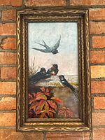 Frontal view of framed oil painting showing swallows and foliage