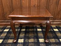 Front view of vintage solid cherry wood end table showing cabriole legs and polished top surface.