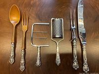Overhead view of all six utensils laid side by side on wooden surface