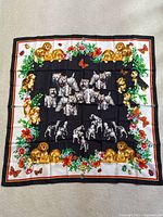 Full view of a square silk scarf with dog illustrations and floral border