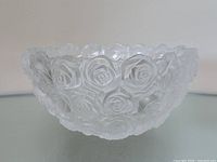 Side view of bowl showing rose relief pattern and frosted exterior.