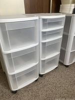 Three large Sterilite storage drawer units on wheels, white color with translucent drawers