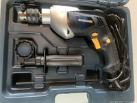 Photo of Mastercraft corded drill with auxiliary handle and chuck key inside carrying case