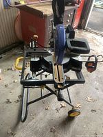 Full view of the Mastercraft miter saw mounted on metal stand with wheels, showing sliding rails and handle.