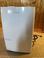 Front view of the white NOMA dehumidifier showing logo and smooth front panel.