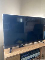 Sharp flat screen TV angled on media cabinet