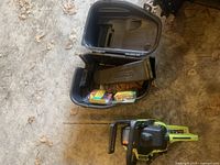 Poulan chainsaw with carrying case open, showing extra chains and accessories inside