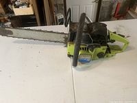 Side view of Poulan Counter Vibe 3700 chainsaw, showing full length with chain on bar and handle grips.