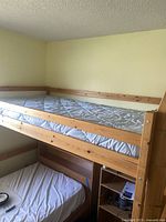 Full front view of pine loft bed frame showing top bunk, long guard rail, and ladder on right side