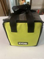 Ryobi branded yellow and gray soft carrying bag with black straps.