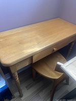 Console table with turned legs and single drawer with cracked drawer knob, light wood finish