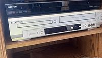 Sony RDR-GX380 DVD Recorder on top and Sylvania CDVC80DP DVD & VHS Player below on shelf.