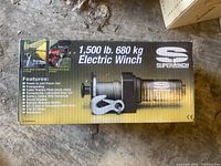 Box front showing Superwinch T1500 Electric Winch with 1,500 lb rated line pull and features listed.
